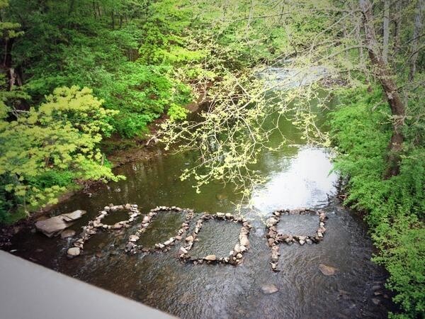 Poop written in a stream with stones.